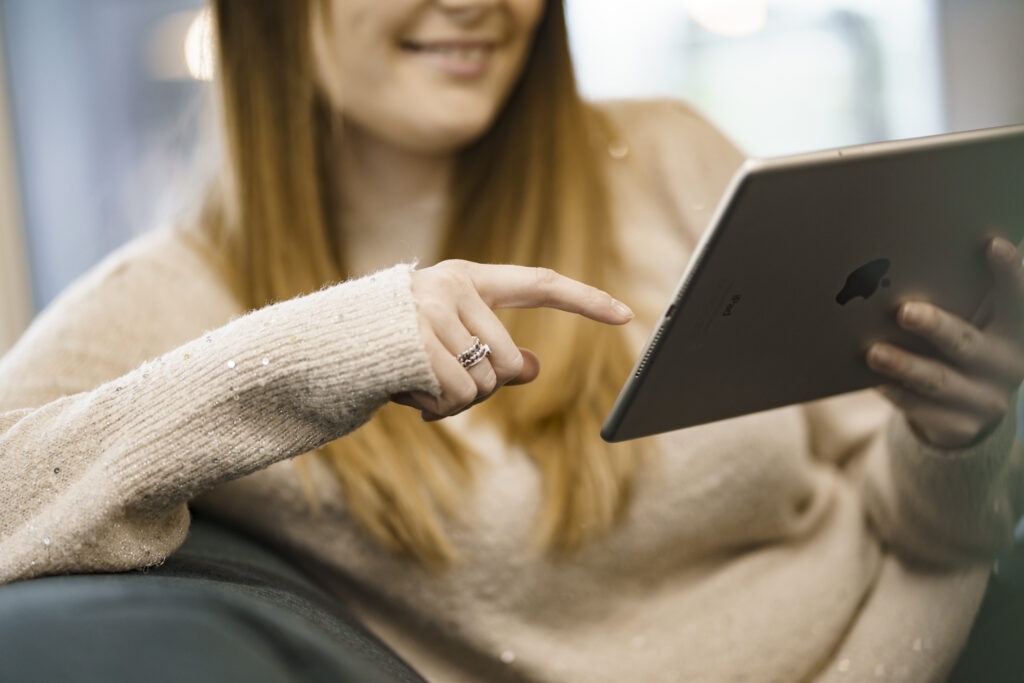 Person holding an iPad, accessing Money Claim Online website.