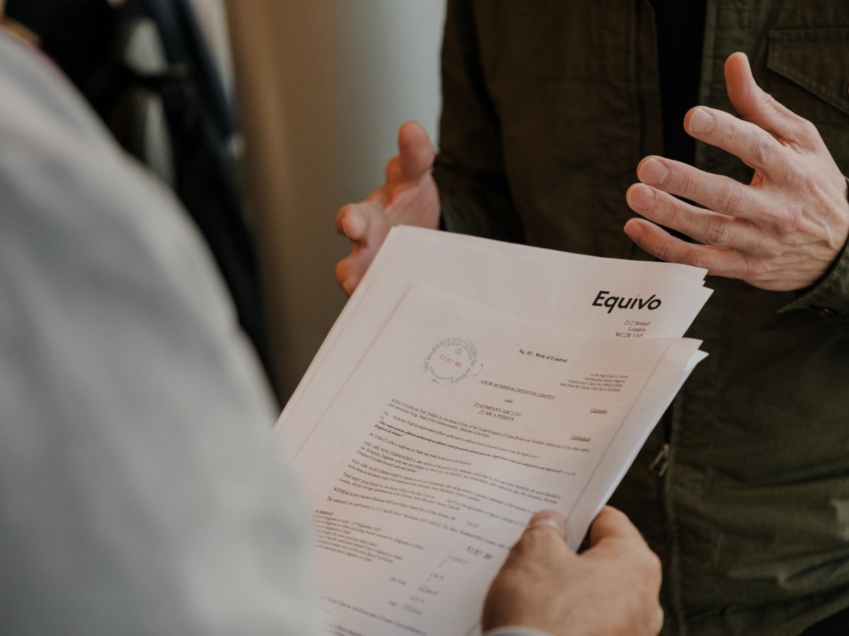 2 professionals discussing paperwork for debt recovery